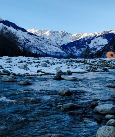 Beautiful snow-covered valley and river in Manali, India capturing the serene winter landscape.