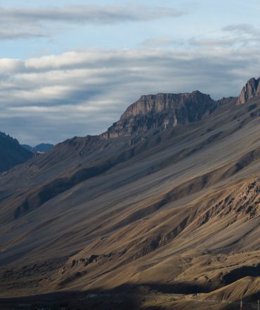 Dramatic view of the Spiti Valley with towering mountains in Himachal Pradesh, India.