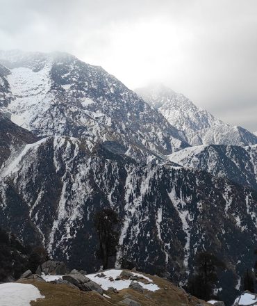 Breathtaking view of snow-covered Himalayan peaks in Dharamshala, India.
