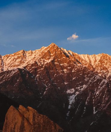 Beautiful mountain range with snow-capped peaks captured during sunset, showcasing natural beauty.